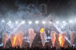 Water cannons firing at the S2O festival crowd while pyrotechnics fire off in the background.