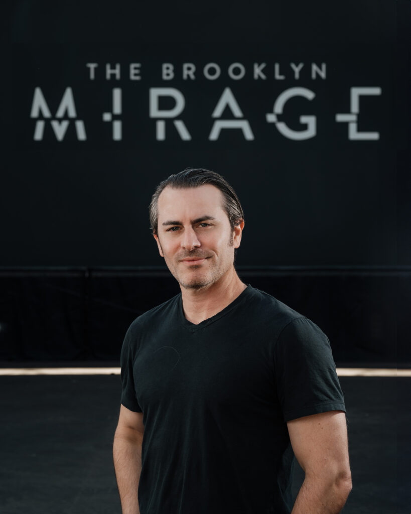 Image of Josh Wyatt in front of The Brooklyn Mirage logo.