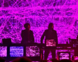 Zeds Dead posing in front of a purple background